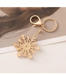 Gros plan d'un porte-clés flocon de neige doré avec fermoir mousqueton sur fond de magazine