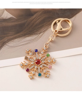Détail d'un porte-clés flocon de neige avec strass multicolores et finition dorée