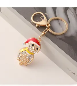 Close-up of sparkling penguin keychain with white rhinestones and festive red Santa hat