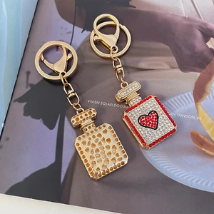 Chic gold heart perfume bottle keychain with shimmering rhinestones for women handbags