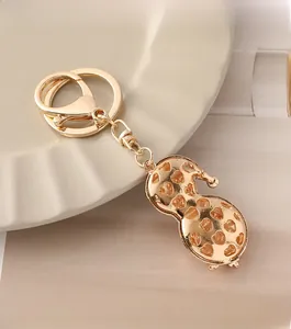 Detail of a golden peanut keychain featuring intricate heart hollow-out patterns on a tray
