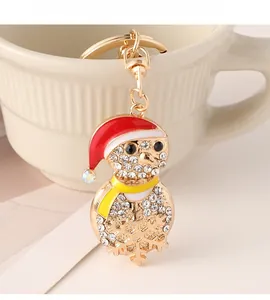 Detailed view of a gold Christmas penguin keychain with sparkling white rhinestones