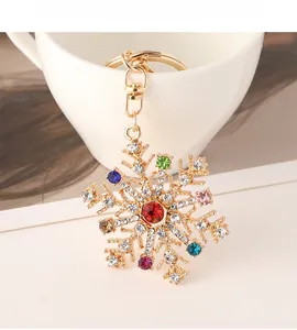 Vue détaillée du porte-clés flocon de neige doré avec cristaux colorés et fermoir homard