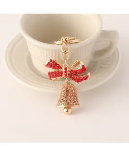 Detailed shot of Christmas bell keychain with red rhinestone bow and golden metal loop