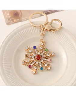 Vue détaillée du porte-clés flocon doré avec des strass colorés sur une assiette