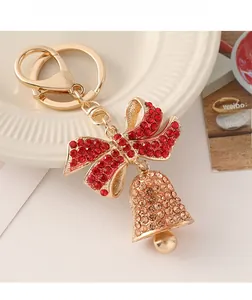 Detailed close-up of a festive Christmas bell keychain with red rhinestones and golden bow