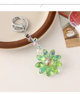 Detailed close-up of a green crystal sunflower keychain with colorful beads on a tray