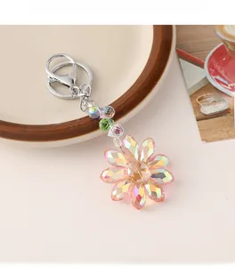 Detail of crystal sunflower keychain featuring pink orange gradient petals and silver clasp