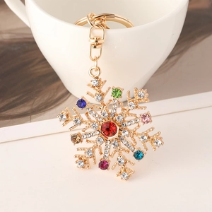 Porte-clés flocon de neige en strass multicolores avec base dorée sur une tasse