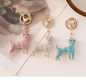 Detailed macro view of diamond-studded dog keychains in pink, white, and light blue colors