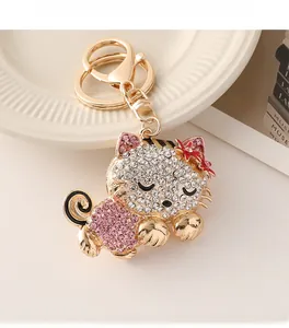 Detail of diamond-encrusted cat keychain with white and pink rhinestones on gold alloy