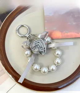 Detail of silver metallic fabric rose with white faux pearls and elegant ribbon charm