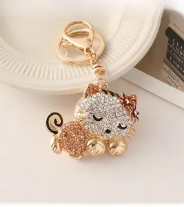 Macro detail of golden cat keychain with sparkling white and pink crystal rhinestones