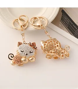 Close-up of golden cat keychains with sparkling rhinestones and hollow heart back detail