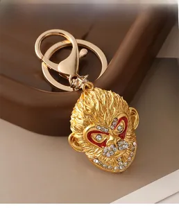 Detail of golden Monkey King keychain featuring red enamel eyes and sparkling white rhinestones