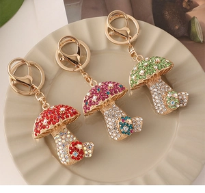 Macro detail of red, pink, and green crystal mushroom keychains on a ceramic tray
