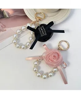 Close-up of handmade mesh rose charms with pearls and gold hardware for bags
