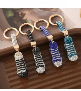 Dettaglio dei portachiavi a scarpa con strass in blu, nero e argento con gancio