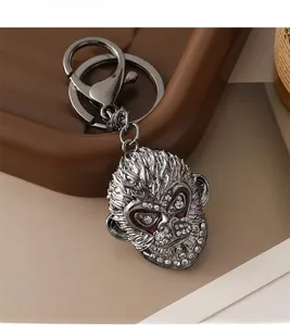 Detail of silver monkey keychain featuring white rhinestones on a textured tray