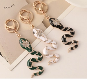 Detail of snake keychains with diamonds and enamel finish in green, white and black