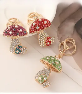 Detail of cute rhinestone mushroom keychains in pink, red, and green with gold metal clips