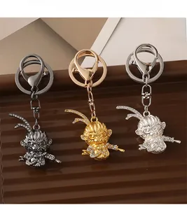Vue détaillée de trois porte-clés Roi Singe en or argent et noir avec strass scintillants