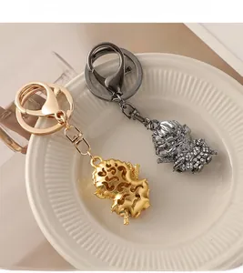Detail view of gold and gunmetal Monkey King keychains with sparkling rhinestone inlay