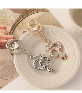 Detailed view of silver and gold snake keychains with sparkling crystal rhinestones