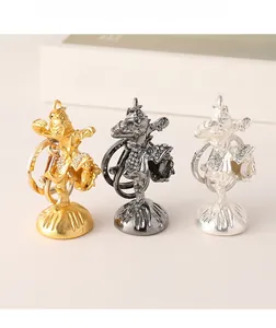 Detailed macro view of three Monkey King keychains in gold, black, and silver alloy with rhinestones