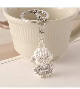 Detail of silver Monkey King keychain with white crystals hanging on a ceramic cup