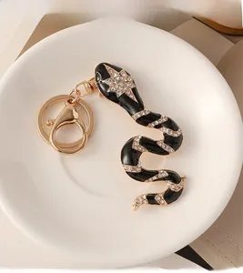 Detail of snake keychain featuring black enamel, white rhinestones and gold-plated alloy