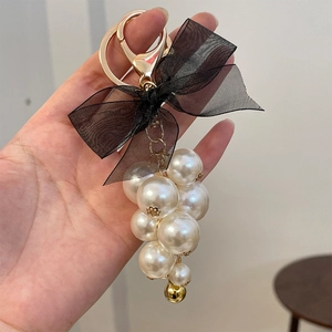 Elegant black tulle bow keychain with white pearl cluster and golden hardware