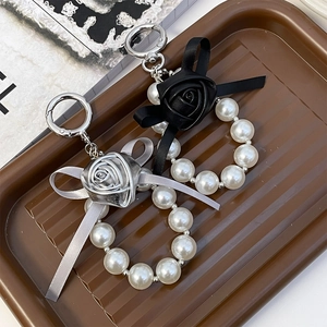 Elegant PU rose keychain with pearl string and bow, shown in black and silver colors