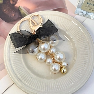 Elegant pearl grape cluster keychain with black mesh bow on a golden lobster clasp