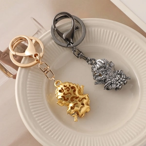 Monkey King keychain with sparkling rhinestones in gold and gunmetal finishes on tray