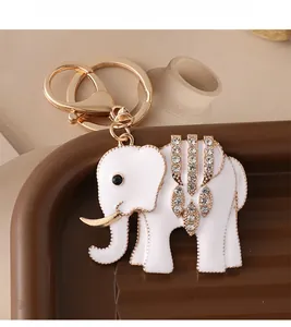 Detail of white enamel elephant keychain with gold trim and sparkling rhinestone back decoration