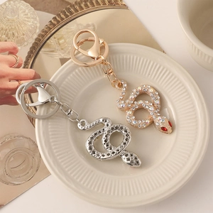 Zodiac snake keychain with crystal diamonds in gold and silver finish on display