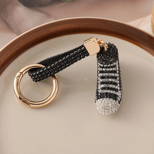 Portachiavi sneaker alta con strass neri e bianchi e anello in metallo dorato