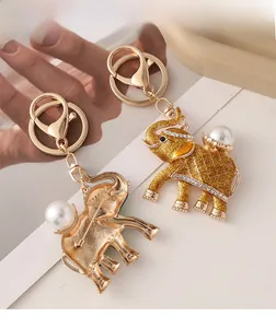 Detail view of gold elephant keychain brooch with white faux pearl and sparkling crystals