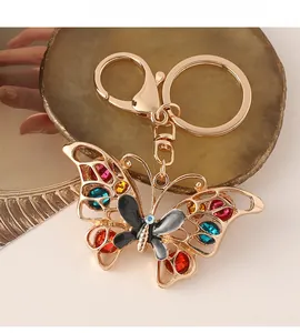 Macro detail of gold-plated butterfly keychain with colorful rhinestones and hollow design
