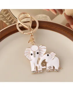 Detailed macro view of the golden elephant keychain with white enamel and sparkling rhinestones