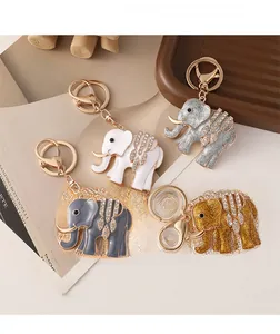 Detailed view of four crystal elephant keychains with gold clasps on a modern tray