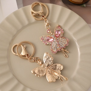 Portachiavi ballerina dorata con strass rosa e bianchi su vassoio in ceramica