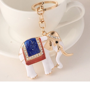 Close-up of white enamel elephant keychain with sparkling rhinestones and gold plating