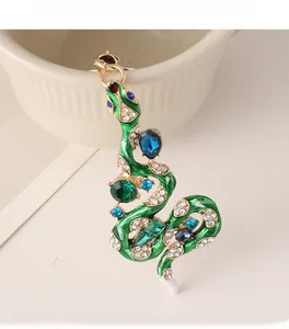 Détail macro du porte-clés serpent en émail vert orné de strass bleus et brillants