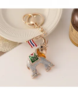 Detailed view of silver glitter elephant keychain with colorful enamel saddle and rhinestones