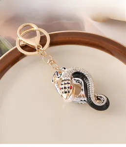 Vue macro du porte-clés serpent avec strass colorés et alliage doré sur plat céramique