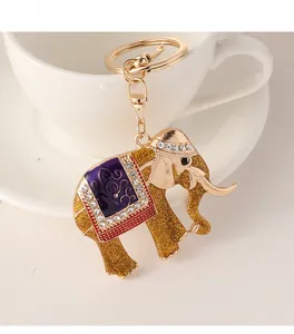Detailed close-up of golden elephant keychain with purple enamel and sparkling rhinestones