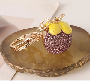 Detailed close-up of mangosteen keychain with purple crystals on brown agate stone