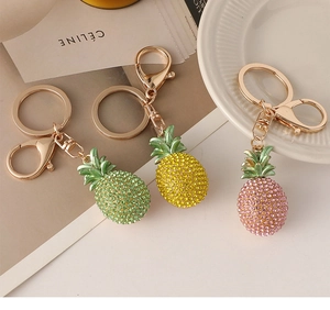 Close-up of sparkling rhinestone pineapple keychain with golden metal ring and lobster clasp